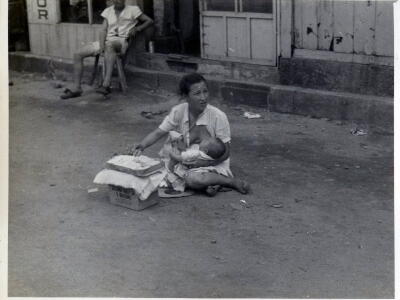 Mother with baby selling cigarettes 1948